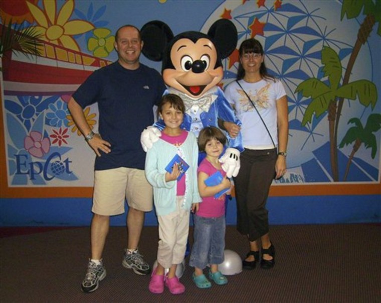 From left to right, Michael Geoffrion, Ajia Geoffrion, 9, Olivia Geoffrion, 5, and Janna Geoffrion as they visit Epcot center while on vacation at Walt Disney World in Orlando, Fla. Divorced in 2006, Mike and Janna have since vacationed together twice with their daughters. 